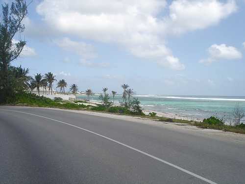 Grand Cayman roadway bending around blue-green Caribbean Bay
